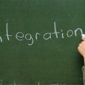 Main féminine écrivant le mot Intégration au tableau